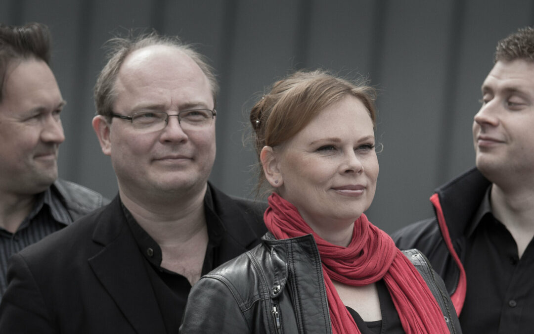 Uusi Helsinki -kvartetti. Neljä henkilöä puolikuvassa, reunimmaiset katsovat toisiinsa, harmaa tausta.