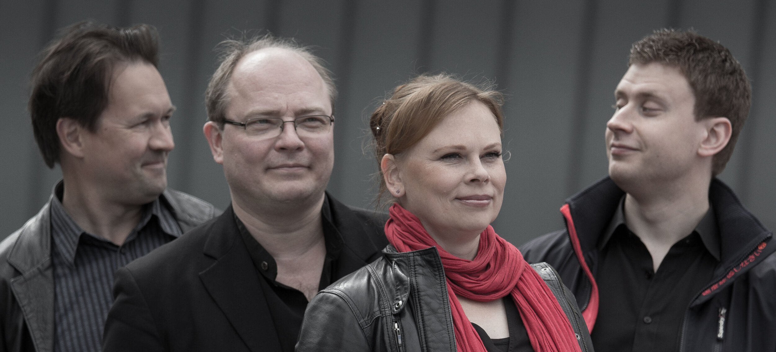 Uusi Helsinki -kvartetti. Neljä henkilöä puolikuvassa, reunimmaiset katsovat toisiinsa, harmaa tausta.