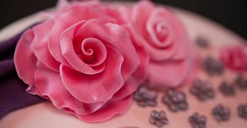 Vaaleanpunaisia ruusunmuotoisia kakkukoristeita.