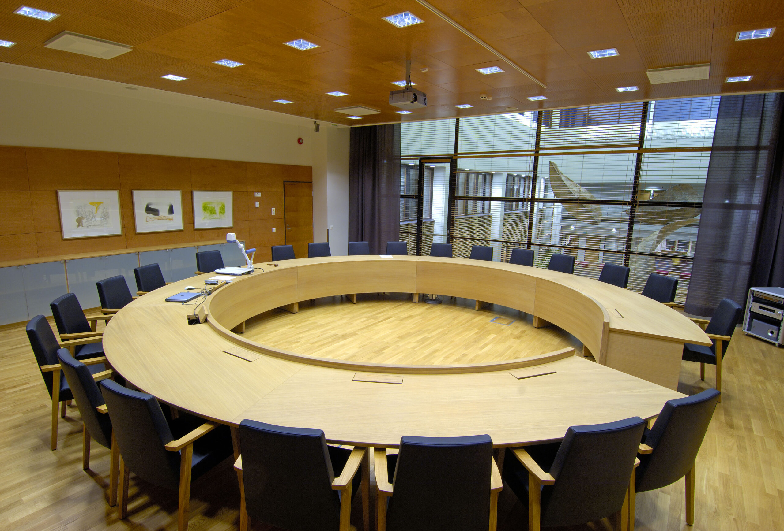 Kokoushuone, jossa on iso pöytä ja tuoleja ympärillä.